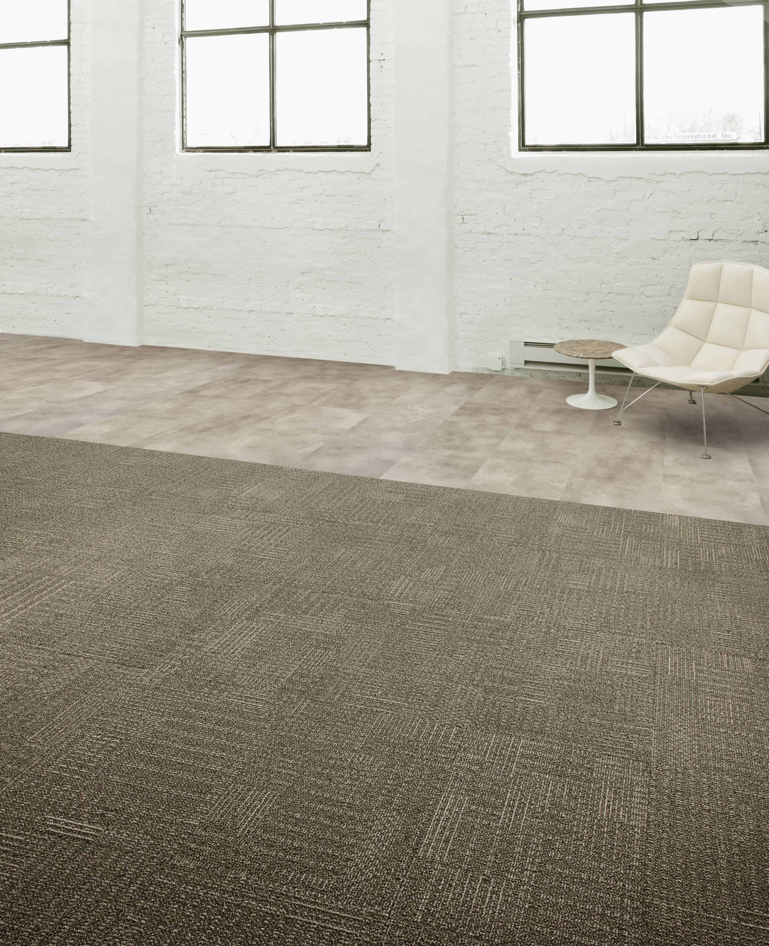 Interface CT101 carpet tile and Textured Stones LVT in open area with concrete walls and chair image number 5